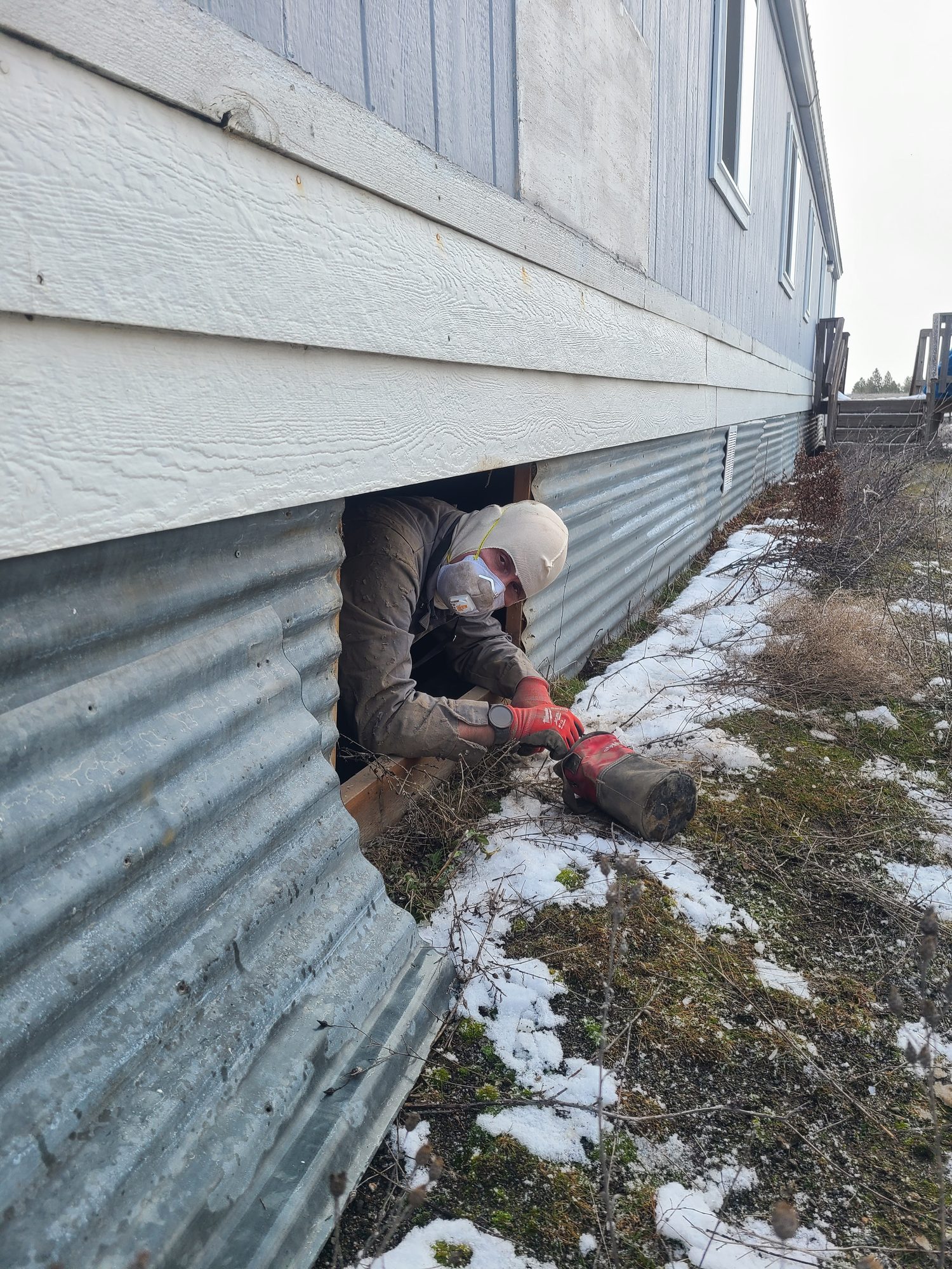Inspector exiting a crawlspace during an inspection