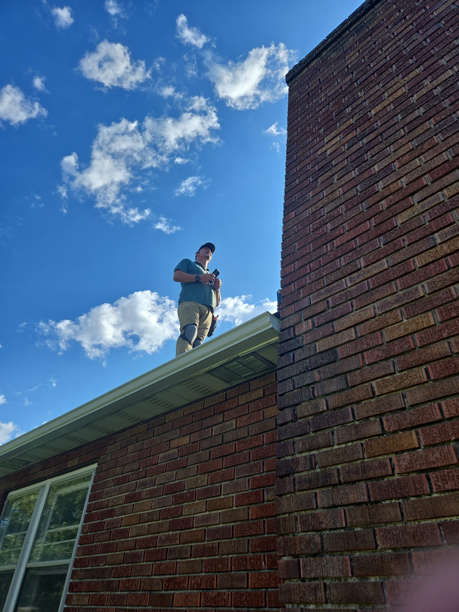 Inspector on a rooftop during a purchase inspection