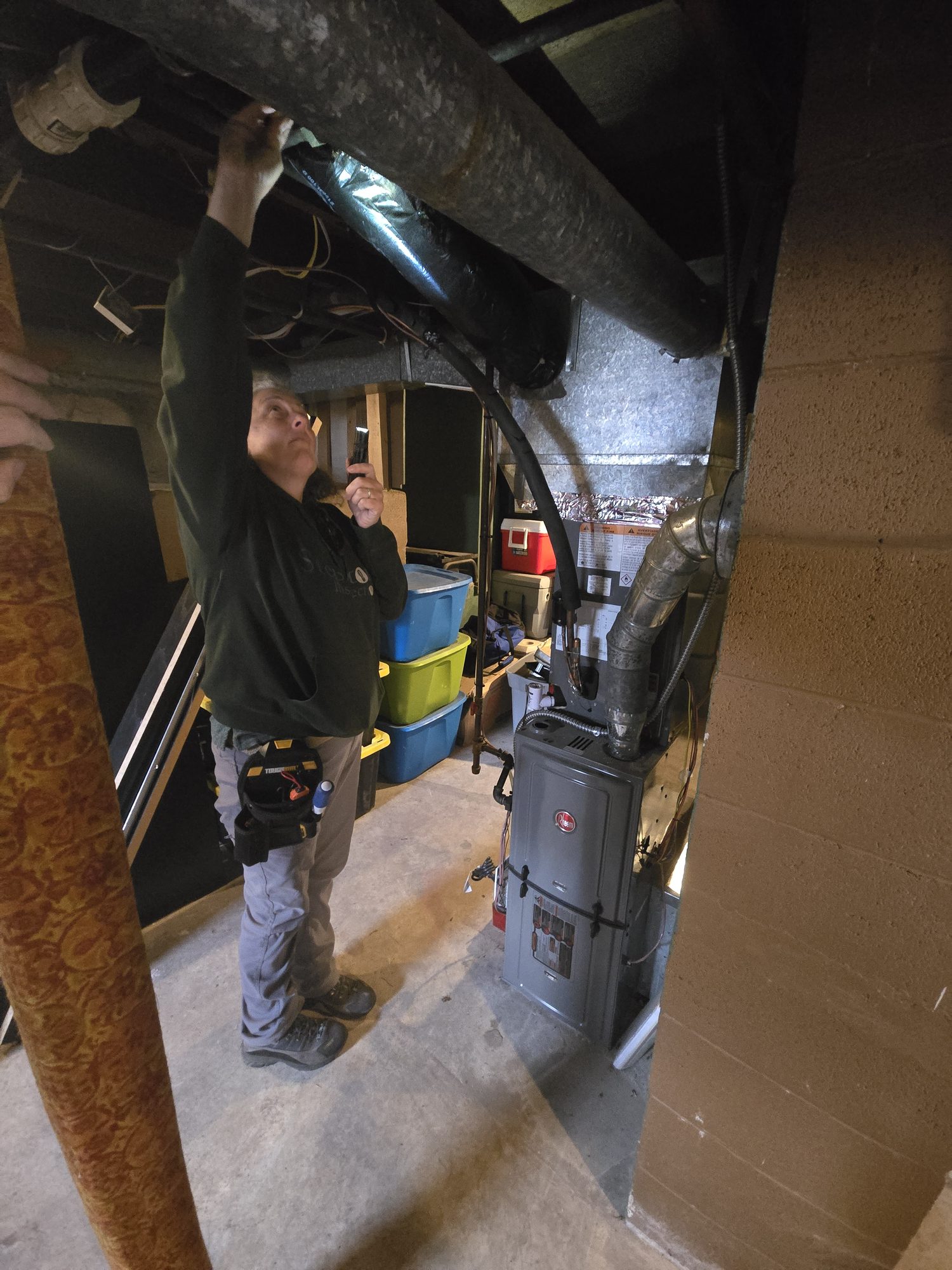 Inspector examining ductwork and a furnace